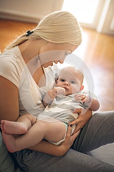 Mother at home holding her baby boy in arms.