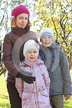 Mother hug son, daughter in autumn forest