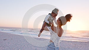 Mother hugging and lifting her daughter at sunset