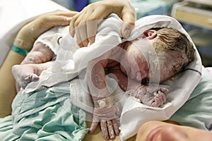 Mother hugging a vernix covered newborn