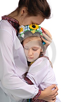 The mother hugs the child with tearful eyes. A child in Ukrainian national clothes