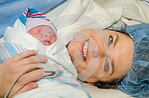 Mother hugs her new infant after delivering child