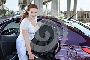 Mother installing child restraint seat in the car