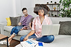 Mother of interracial family working using computer laptop at home depressed and worry for distress, crying angry and afraid