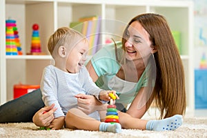 Mother and kid boy play together indoor at home