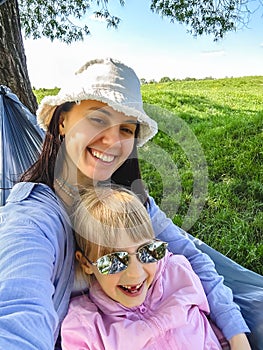 mother with kid daughter in hammock smiling