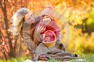 Mother and kid have pinic together in autumn park