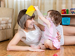 Mother and kid having fun pastime indoors photo