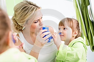 Mother and kid with neti pot for nasal irrigation