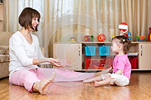 Mother and kid play with ball indoors