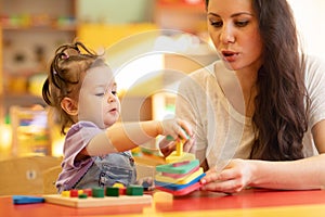 Mother and kid playing colorful block toys at home