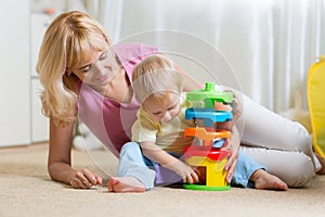 Mother and kid playing with colorful logical toy
