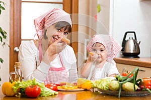 Mother and kid preparing healthy food and having fun