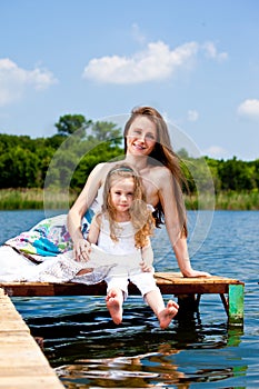 Mother and kid sit on bridge