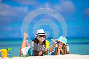 Mother and kid with suntan lotion on tropical