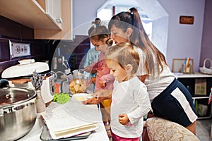 Mother with kids cooking at kitchen, happy children`s moments