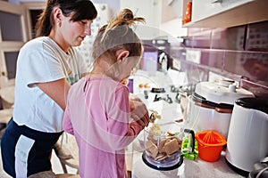 Mother with kids cooking at kitchen, happy children`s moments