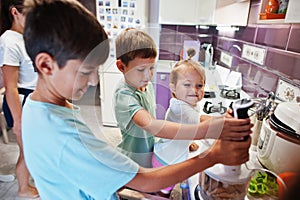 Mother with kids cooking at kitchen, happy children`s moments