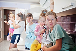 Mother with kids cooking at kitchen, happy children`s moments