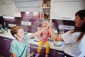 Mother with kids cooking at kitchen, happy children`s moments