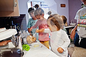 Mother with kids cooking at kitchen, happy children`s moments