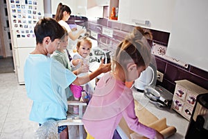 Mother with kids cooking at kitchen, happy children`s moments