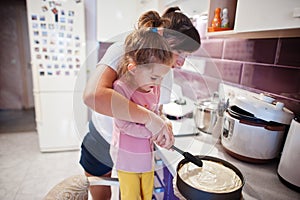 Mother with kids cooking at kitchen, happy children`s moments