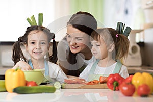 Mother and kids daughters having fun in the kitchen