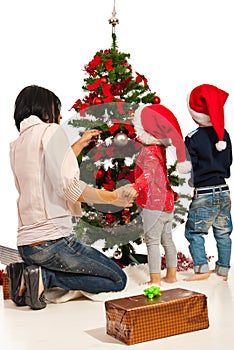 Mother with kids decorate tree photo