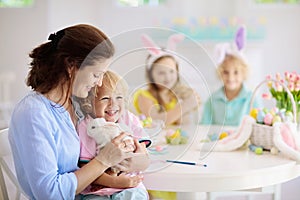 Mother and kids, family coloring Easter eggs