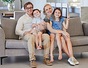 Mother, kids and father in a happy family portrait on sofa in a lovely home and enjoying quality time in the living room