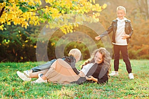 Mother and kids having fun outdoors. Fashionable family walking in autumn nature. Family, fashion and lifestyle