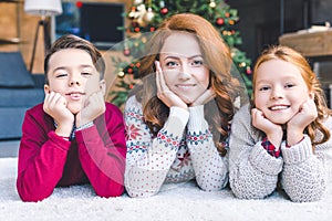 Mother and kids laying on floor on christmas