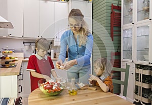 Mother and kids making salad on the kitchen