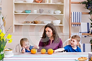 Mother and kids at the table in the kitchen. Happy family concept