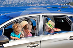 Mother with kids travel by car at the sea