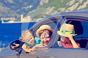 Mother with kids travel by car at the sea