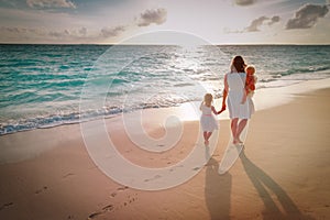 Mother with kids walk on sand beach