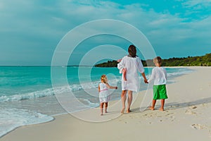 Mother with kids walk on tropical beach vacation