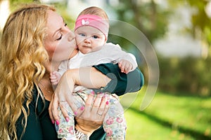 Mother kiss baby in hands