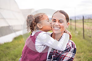 Mother, kiss and girl on a sustainability, agriculture and ecology farm with family love and care. Portrait of a mama