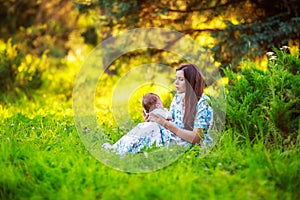 Mother kisses baby son, close-up, summer