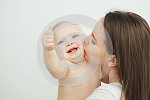 Mother kisses her adorable toddler in cheek, enfant posing