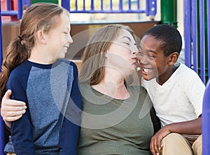 Mother kissing adopted son on cheek photo