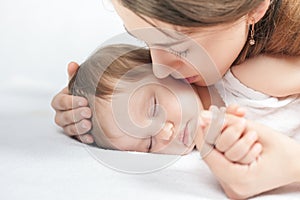 Mother kissing a baby. Care concept