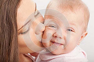 Mother kissing baby girl