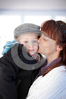 Mother kissing cute toddler