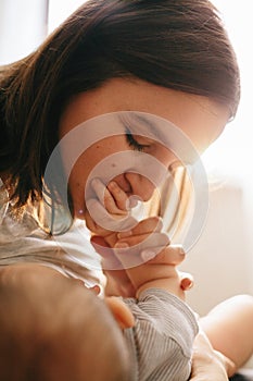 Mother kissing a hand of her baby boy. Love Emotional Family