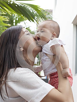 Mother kissing on her baby cheek use for motherhood and infant i