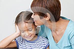 Mother kissing her daughter